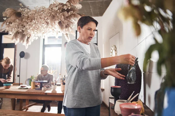 Femme mûre passer du temps à la classe de maître d'art à l'intérieur du studio de création — Photo