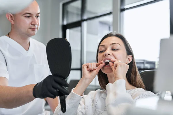 Male Doctor Holding Mirror While Patient Woman Putting Invisible Braces — Stock Photo, Image