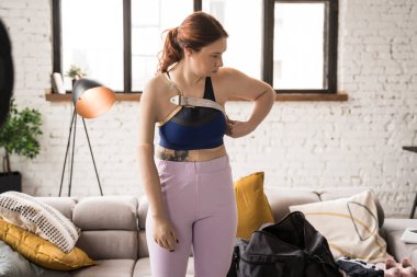 Engelli kadının evde dikilirken yapay kolunu kendine dayayışını tam olarak görebiliyoruz. Yurtiçi yaşam tarzı kavramı