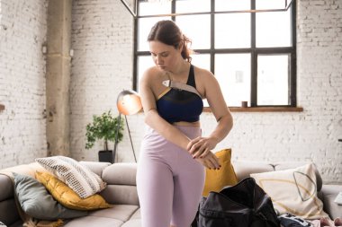 Kafkas kadının evde dikilirken biyonik uzvuna baktığı uzun bir manzara. Yurtiçi yaşam tarzı kavramı