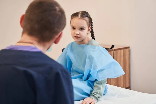 Маленькая Милая Девочка Спрашивает Своего Врача Сидя Больничной Койке Ожидая — стоковое фото