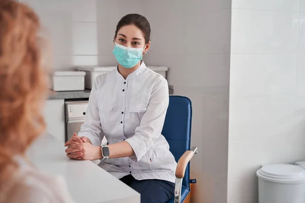 女医生戴着防护面具在办公室工作 听病人讲话 她正在解释自己的症状 保健和援助概念 — 图库照片
