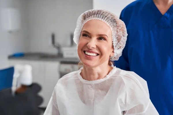 Šťastná Běloška Ochranném Oděvu Směje Zatímco Čeká Zákrok Její Doktor — Stock fotografie