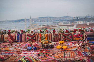 İstanbul 'un büyük panoramik manzarası terastan geleneksel renkli süs yastıkları ve halılar ile süslenmiş ve meyve, Türk çayı ve nargileyle dolu.
