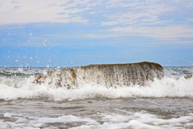 Mavi gökyüzünün altındaki Baltık Denizi sahillerinde dalgalar