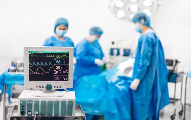 Profesyonel anestezi uzmanı doktor tıp ekibi ve asistanı modern hastane acil servisinde cerrahi ekipmanla jinekolojik ameliyata hazırlanıyor.