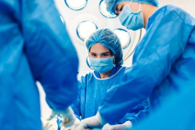 Profesyonel anestezi uzmanı doktor tıp ekibi ve asistanı modern hastane acil servisinde cerrahi ekipmanla jinekolojik ameliyata hazırlanıyor.