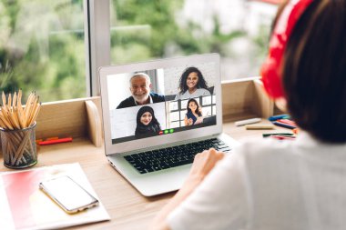 Kadın konuşması, dizüstü bilgisayarın çalışması ve evdeki iş arkadaşlarıyla çevrimiçi video konferansı kullanarak konuşuyor. Yaratıcı kadın, ev konseptinden iş ekibiyle görüntülü konuşma görüşmesi yapıyor.