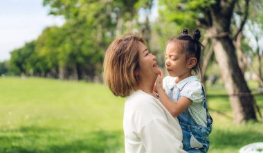 Mutlu aşk portresi Asyalı büyükanne ve küçük tatlı Asyalı kız yaz parkında rahatlayın. Büyük anne ve babası birlikte gülümseyen genç kız. Aile ve beraberlik.