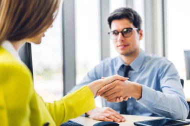 İmaj iki iş ortağının başarılı bir şekilde tokalaşması ve modern ofiste başarılı bir şekilde el sıkışması. Ortaklık onayı ve teşekkürler jest konsepti.