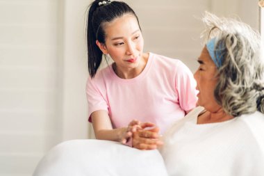 Mutlu bir aşk portresi. Asyalı mutlu bir aile. Yaşlı, olgun bir anne ve genç bir kız. Gülümseyen, kucaklayan ve kucaklayan.