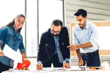 İnşaat alanındaki inşaat sahasında mimari tasarım ve inşaat araçlarıyla yeni inşaat projeleri planında çalışan mimar sanayi mühendisi ustabaşı profesyonel bir inşaat mühendisi.