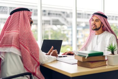 Üniversiteli Arap iş adamlarının dizüstü bilgisayar ve belge raporlarıyla çalışmalarının başarısı. Yaratıcı Arap iş adamları yeni bir başlangıç projesi projesiyle buluşup strateji analizi planlıyorlar.