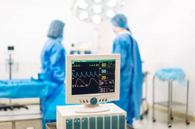 Profesyonel anestezi uzmanı doktor tıp ekibi ve asistanı modern hastane acil servisinde cerrahi ekipmanla jinekolojik ameliyata hazırlanıyor.