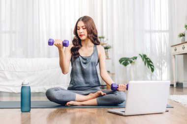 Portre sporu spor, spor kıyafetleri içinde ince kadın, rahatlama ve yoga yapan kız, yatak odasında dizüstü bilgisayarla spor yapıyor. Diyet konsepti. Fitness ve sağlıklı.