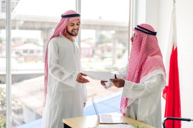 Üniversiteli Arap iş adamlarının dizüstü bilgisayar ve belge raporlarıyla çalışmalarının başarısı. Yaratıcı Arap iş adamları yeni bir başlangıç projesi projesiyle buluşup strateji analizi planlıyorlar.
