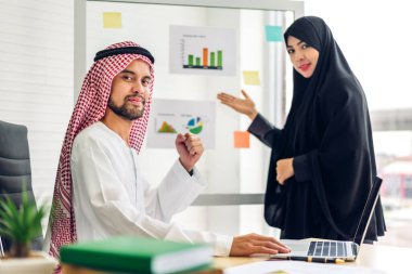 Üniversiteli Arap iş adamlarının dizüstü bilgisayar ve belge raporlarıyla çalışmalarının başarısı. Yaratıcı Arap iş adamları yeni bir başlangıç projesi projesiyle buluşup strateji analizi planlıyorlar.