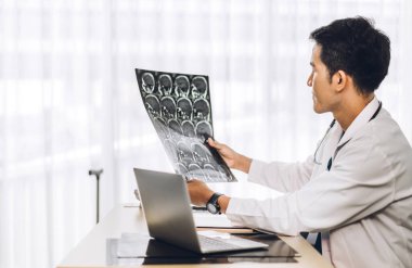 Steteskopla üniforma giyen Asyalı doktor hastanede dizüstü bilgisayarla çalışıyor. Sağlık ve tıp.