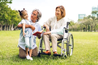 Mutlu aşk portresi Asyalı büyükbaba ve büyükannesi ve Asyalı küçük tatlı kız yaz parkında rahatlayın. Gülen büyükannesi ve büyükbabası birlikte gülümseyen genç kız. Aile ve beraberlik.