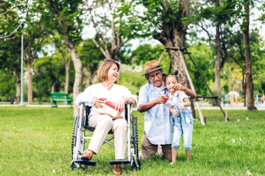 Mutlu aşk portresi Asyalı büyükbaba ve büyükannesi ve Asyalı küçük tatlı kız yaz parkında rahatlayın. Gülen büyükannesi ve büyükbabası birlikte gülümseyen genç kız. Aile ve beraberlik.