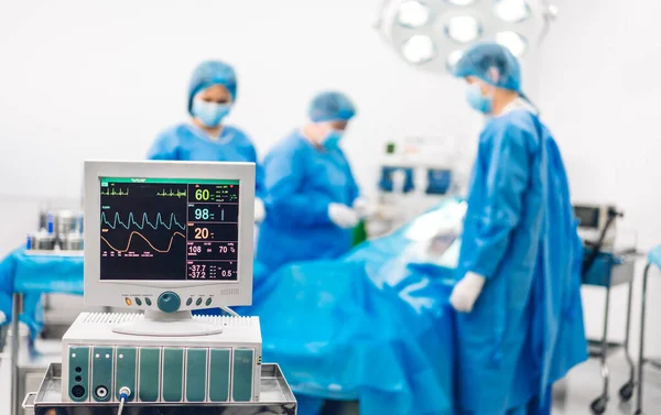 Profesyonel anestezi uzmanı doktor tıp ekibi ve asistanı modern hastane acil servisinde cerrahi ekipmanla jinekolojik ameliyata hazırlanıyor.