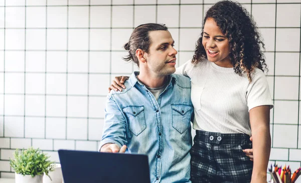 Birlikte dizüstü bilgisayarla çalışan mutlu bir çift. Yaratıcı iş çifti planlama ve evdeki oturma odasında beyin fırtınası videosu konferansı.