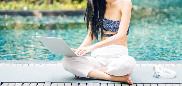 Portrait of smiling happy beauty asian freelancer traveler blogger woman relax using and work technology of laptop computer in swimming pool on summer travel vacation relaxing at resort spa