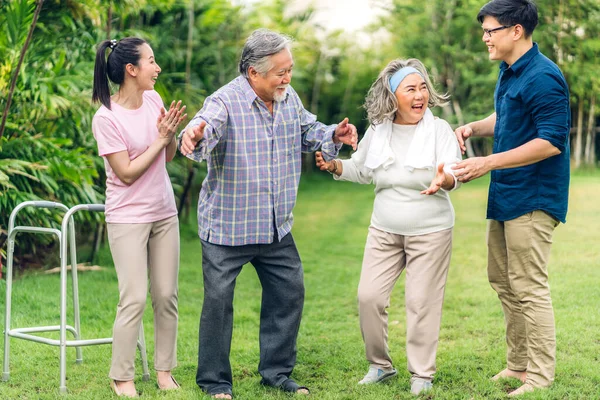 Portre, mutlu, mutlu, gülümseyen, çok nesilli, Asyalı, büyük bir ailenin keyfini çıkarın. Yaşlı, olgun bir baba ve genç, yetişkin bir kadın ve oğlu olan yaşlı bir anne, evde parkta yürüyor. Sigorta kavramı.