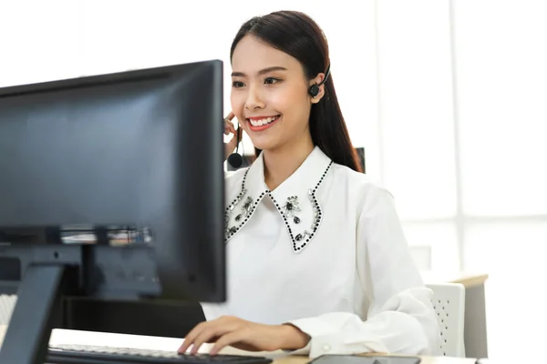 美丽而快乐的呼叫中心微笑的女经营者客户支持咨询电话服务 包括无线耳机和呼叫中心办公室的计算机 — 图库照片