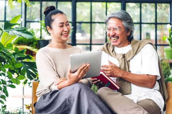 Üst düzey Asyalı çift tablet bilgisayarlarını birlikte kullanırken iyi vakit geçiriyor. Mutlu yaşlı karı koca sosyal medyayı kontrol ediyor, haberleri okuyor ya da evde otururken internetten alışveriş yapıyor.