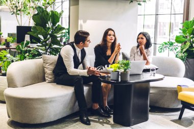 Profesyonel iş grupları yeni projeyle strateji paylaşım fikrini tartışıyor. Yeşil santral terasında çalışan ve konuşan yaratıcı iş adamları modern çalışma odalarında çalışıyor.