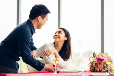 Genç yakışıklı adam sevgilisine sürpriz yapmak için yüzük veriyor ve sevgililer gününde restoranda konuşuyor.