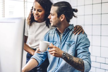 İki profesyonel iş adamı ve kadın verileri analiz ederek ve yeni bir başlangıç projesiyle stratejiyi tartışarak buluştu. Modern ofiste masaüstü bilgisayarla planlama ve beyin fırtınası yapan yaratıcı iş adamları. Takım çalışması