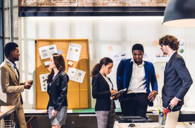 Profesyonel iş toplantısı ve yeni başlangıç projesiyle strateji tartışması. Modern ofiste dizüstü bilgisayarla yaratıcı Afro-Amerikan adam planlama ve beyin fırtınası. Takım çalışması.