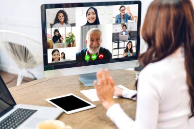 Kadın konuşması, dizüstü bilgisayarın çalışması ve evdeki iş arkadaşlarıyla çevrimiçi video konferansı kullanarak konuşuyor. Yaratıcı kadın, ev konseptinden iş ekibiyle görüntülü konuşma görüşmesi yapıyor.