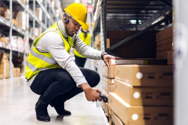 Afro-Amerikan mühendis portresi. Barkod tarayıcı ile tarama paketi. Depoda ulaşım ve dağıtım ürünlerini kontrol et. Lojistik Endüstriyel ve iş ihracatı.