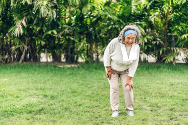 Hasta, yaşlı, yaşlı, kas sakatlığı olan bacağına dokunan yaşlı bir Asyalı kadın parkta diz ağrısı çekiyor. Fiziksel yaralanma ve sağlık sigortası çaylağı.