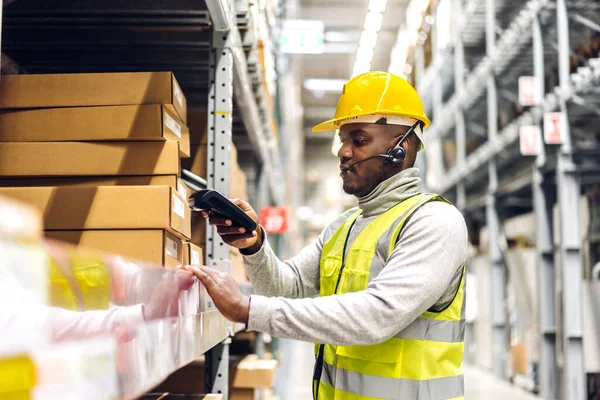 Portrait of smiling african american engineer man order details on tablet checking goods and supplies on shelves with goods background in warehouse.logistic and business export