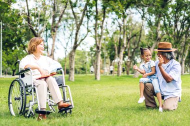 Mutlu aşk portresi Asyalı büyükbaba ve büyükannesi ve Asyalı küçük tatlı kız yaz parkında rahatlayın. Gülen büyükannesi ve büyükbabası birlikte gülümseyen genç kız. Aile ve beraberlik.