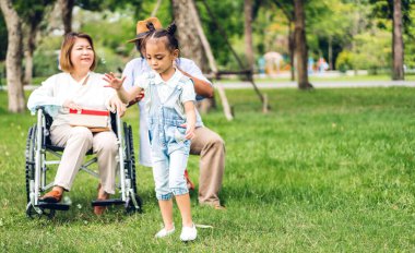 Mutlu aşk portresi Asyalı büyükbaba ve büyükannesi ve Asyalı küçük tatlı kız yaz parkında rahatlayın. Gülen büyükannesi ve büyükbabası birlikte gülümseyen genç kız. Aile ve beraberlik.