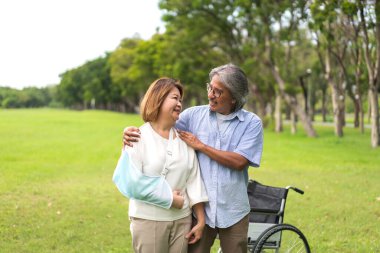 Romantik aile tatlı, mutlu, mutlu, yaşlı Asyalı çift eğleniyor ve gülümsüyor. Mutlu Asyalı yaşlı karı-koca parkta sarılıyorlar. Sigorta kavramı.