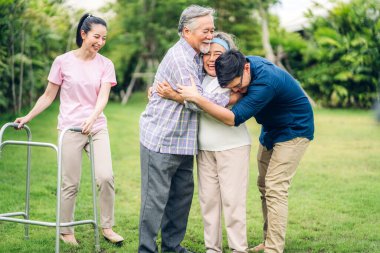 Portre, mutlu, gülümseyen, çok nesildir gülümseyen Asyalı büyük kucaklama ailesinin keyfini çıkarın. Yaşlı bir baba ve yaşlı bir anne ve genç bir kadın ve oğlu ile birlikte evde park halinde. Sigorta kavramı.