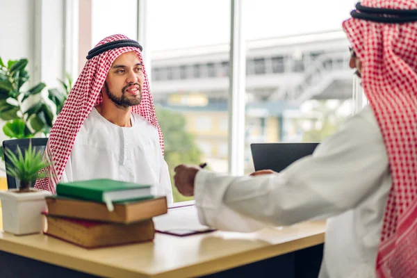 Üniversiteli Arap iş adamlarının dizüstü bilgisayar ve belge raporlarıyla çalışmalarının başarısı. Yaratıcı Arap iş adamları yeni bir başlangıç projesi projesiyle buluşup strateji analizi planlıyorlar.