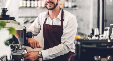 Gülümseme portresi yakışıklı sakallı barista başlangıçta dizüstü bilgisayarla çalışan küçük işletme sahibi bir kafede tezgahın arkasındaki müşteriden emir alır.
