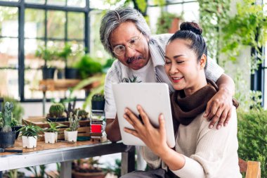 Üst düzey Asyalı çift tablet bilgisayarlarını birlikte kullanırken iyi vakit geçiriyor. Mutlu yaşlı karı koca sosyal medyayı kontrol ediyor, haberleri okuyor ya da evde otururken internetten alışveriş yapıyor.