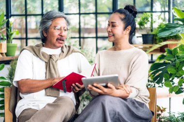 Üst düzey Asyalı çift tablet bilgisayarlarını birlikte kullanırken iyi vakit geçiriyor. Mutlu yaşlı karı koca sosyal medyayı kontrol ediyor, haberleri okuyor ya da evde otururken internetten alışveriş yapıyor.