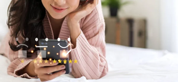 Portrait of customer woman use smartphone and give feedback icon satisfaction survey and customer service with top service excellent rating five star.satisfaction and customer service concept