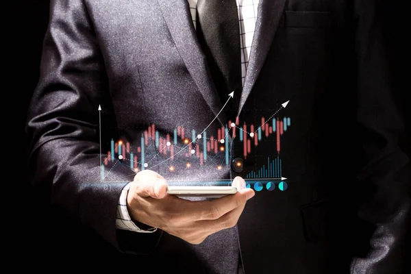 Success Businessman in elegant black suit use digital smartphone looking at screen progress of business financial investment data graph and chart business growth increase