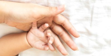 Mutlu bir aşk portresi. Asyalı anne, sevimli bir Asyalı bebekle oynuyor. Anne, tatlı oğluyla beyaz bir odada güzel vakit geçiriyor.