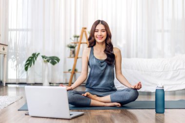 Portre sporu spor, spor kıyafetleri içinde ince kadın, rahatlama ve yoga yapan kız, yatak odasında dizüstü bilgisayarla spor yapıyor. Diyet konsepti. Fitness ve sağlıklı.